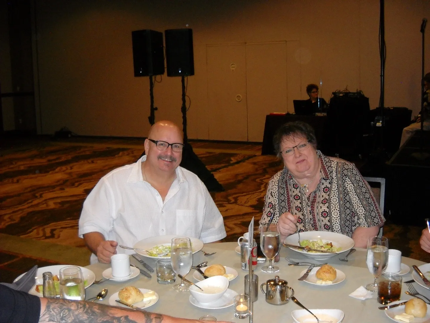 A man and woman sitting at a table with plates of food.